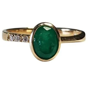 Anillo de oro con esmeralda colombiana de Muzo en engaste ovalado y detalles de diamantes, diseño lujoso y exclusivo.