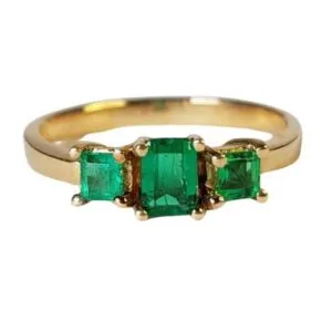 Anillo de oro con tres esmeraldas colombianas de Muzo, diseño exclusivo y lujoso.