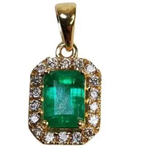 Dije de oro con esmeralda colombiana de Muzo, rodeada de diamantes, diseño elegante y exclusivo.